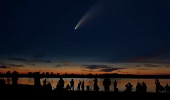 people observing a comet in the night sky