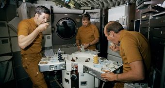 three astronauts enjoying their space meal